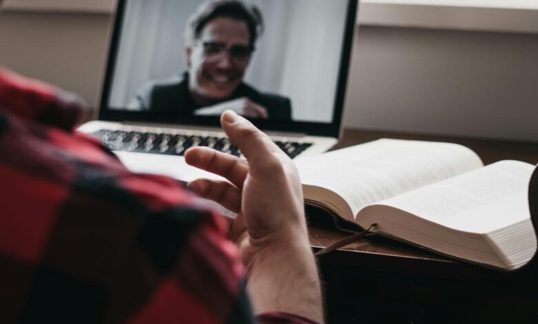 person in red and black plaid long sleeve shirt using black laptop computer