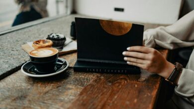 a woman sitting at a table using a laptop computer