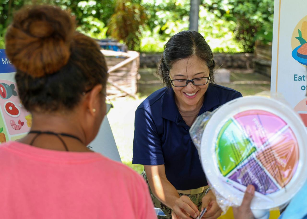 A woman shows a colorful plate to another person.